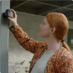 Mujer ajustando una cámara del pack Blink Outdoor 4 en el soporte de pared exterior.
